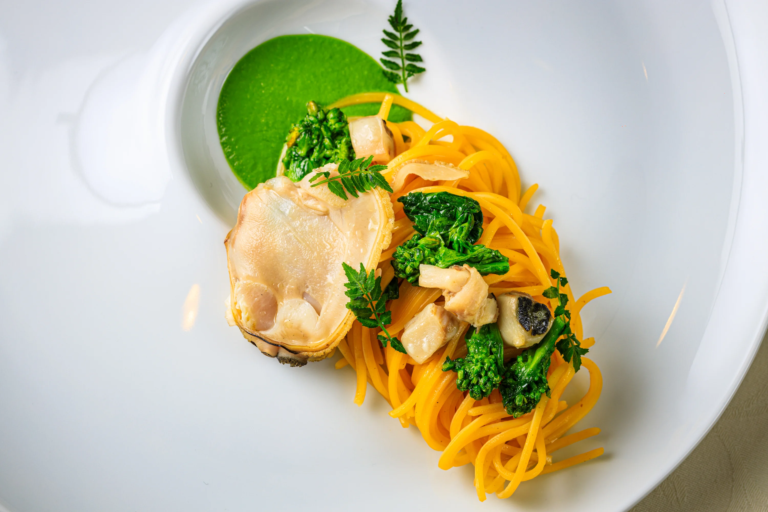 A dark stone presentation with truffle-like elements and greens.