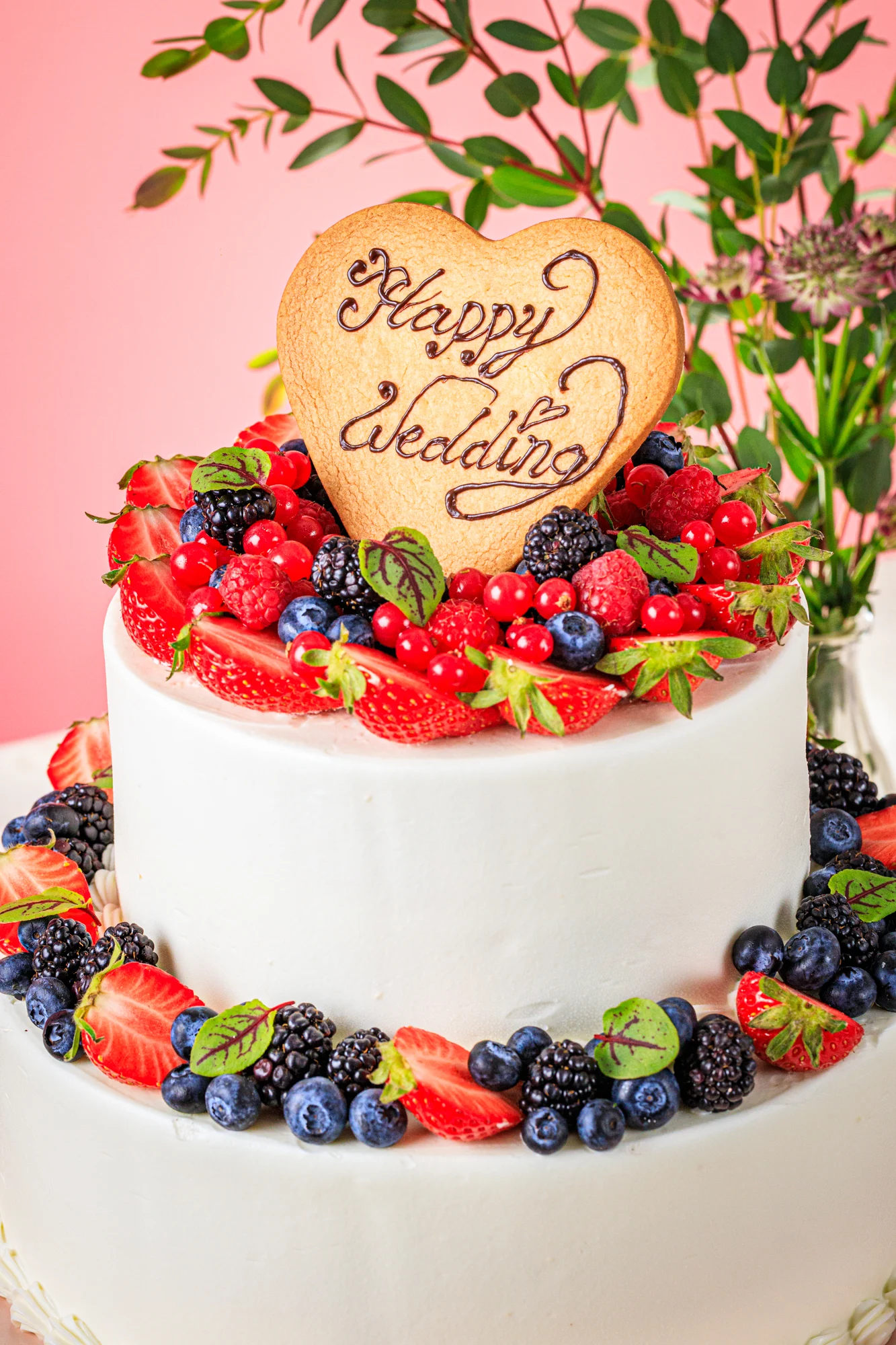 A tiered citrus cake decorated with dried orange slices and greenery.