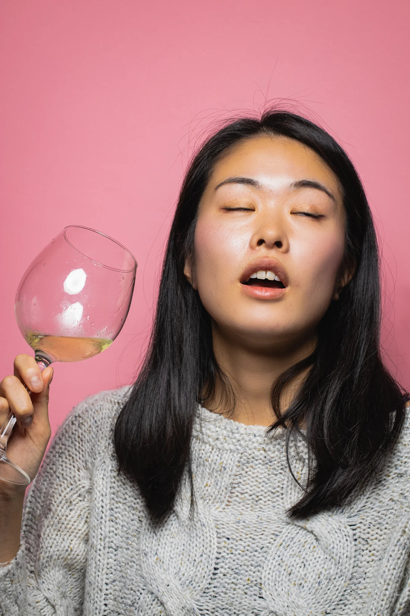A woman holding a wine glass during a playful portrait session.