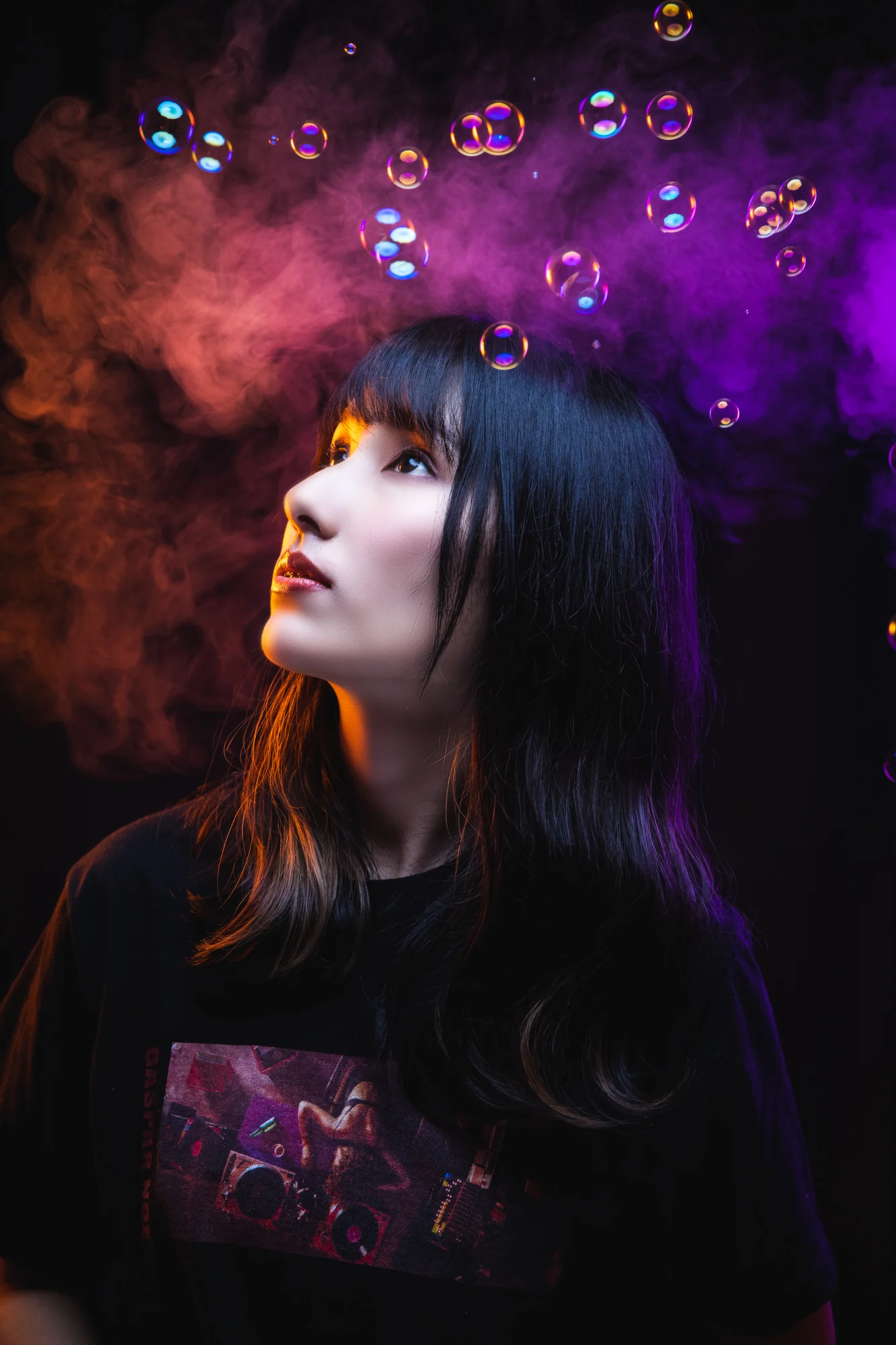A woman's profile surrounded by theatrical purple and red smoke.